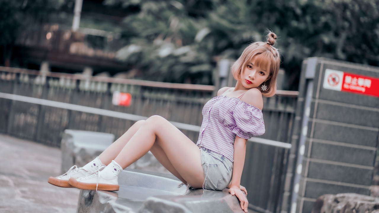 Милая девушка азиатка сидит на камне