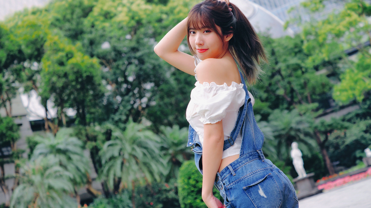 Милая девушка азиатка в джинсовом комбинезоне