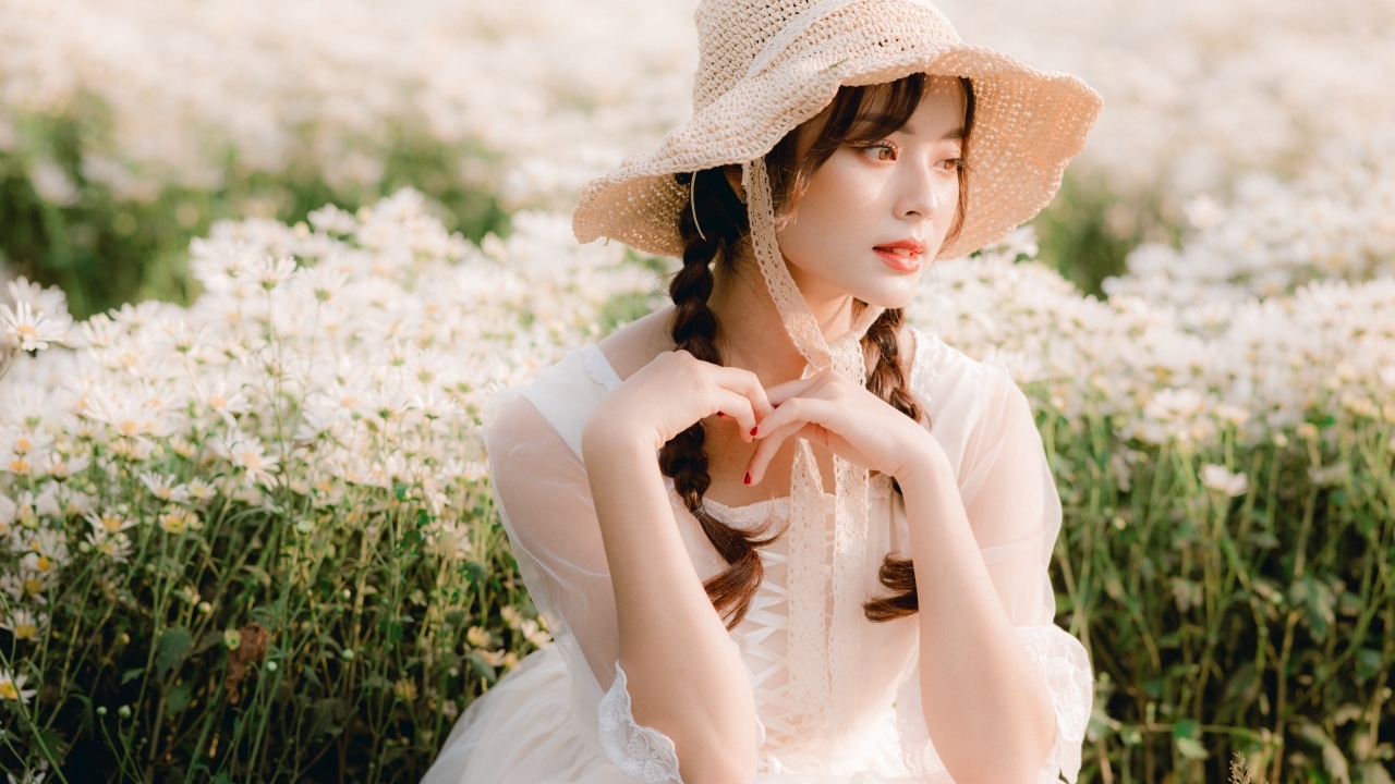 Милая азиатка в шляпе и белом платье 