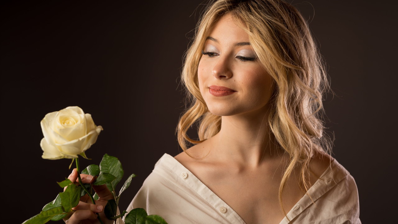 Милая девушка в рубашке с розой в руках