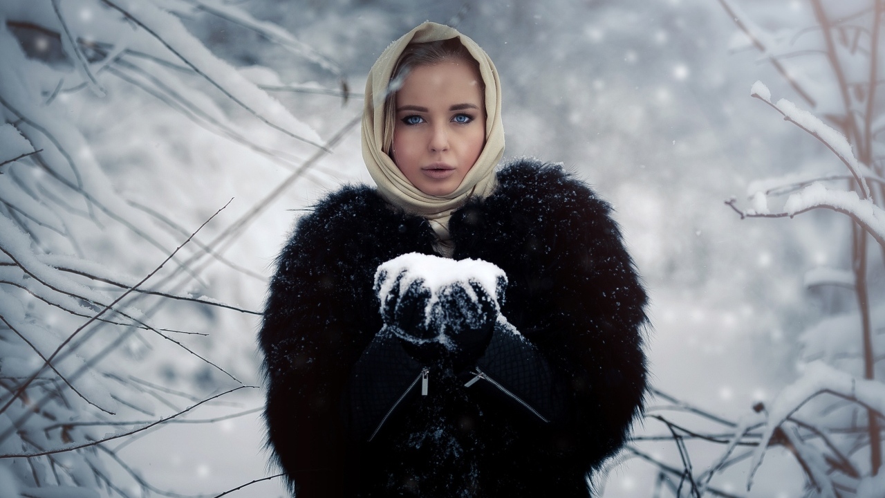 Девушка в черной шубе в заснеженном лесу