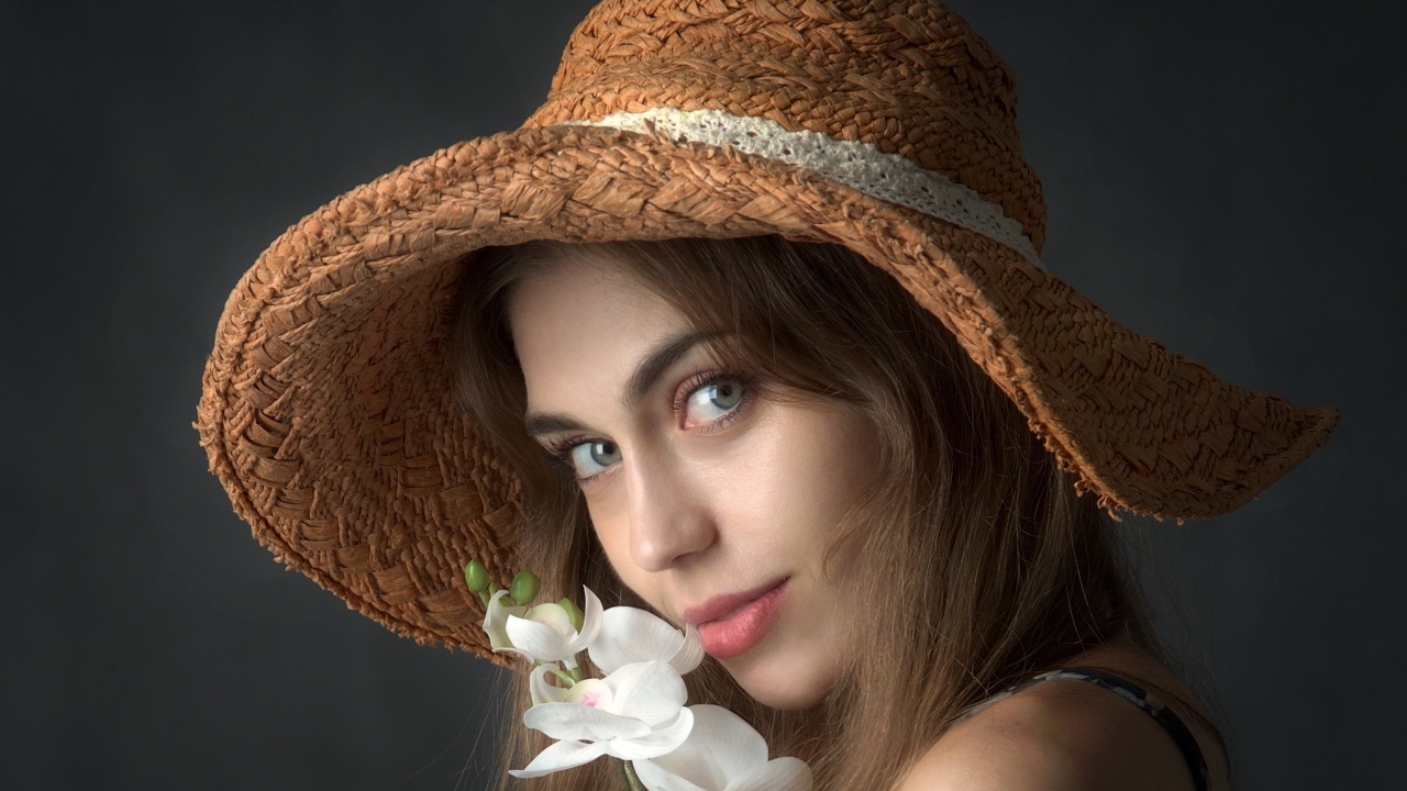 Девушка в шляпе с цветами орхидеи