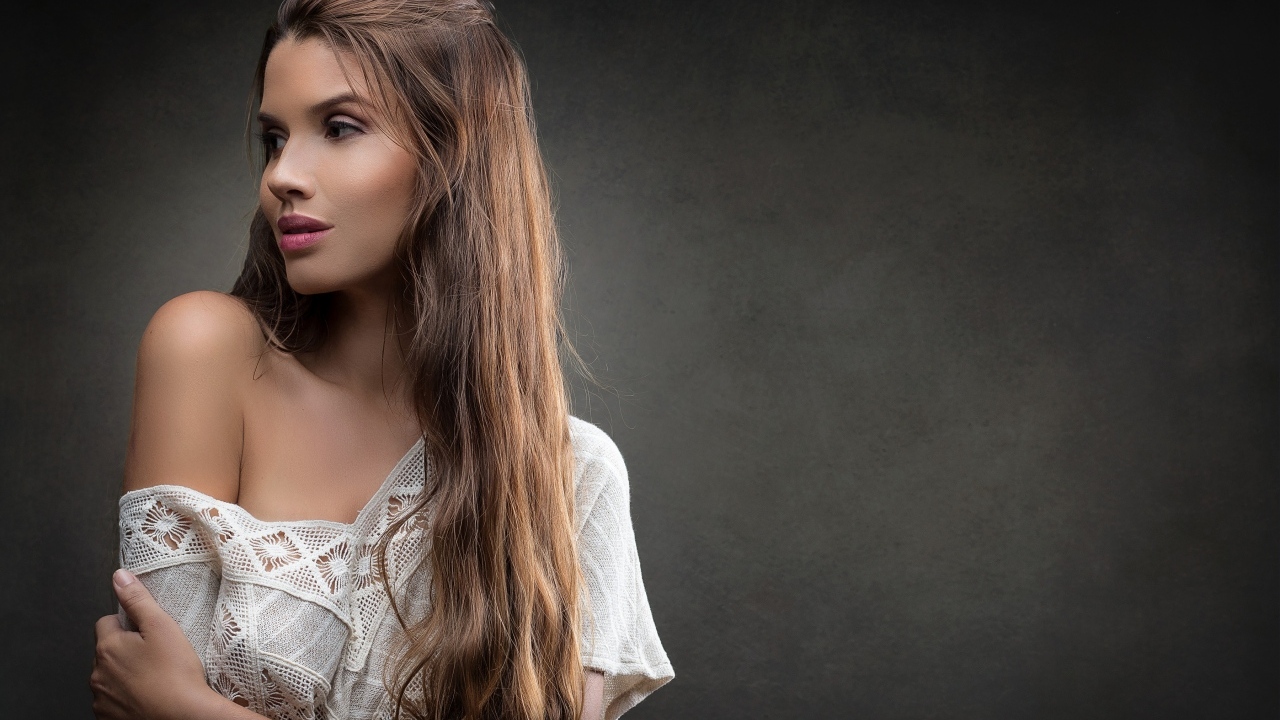 Девушка в белом платье с длинными волосами на сером фоне