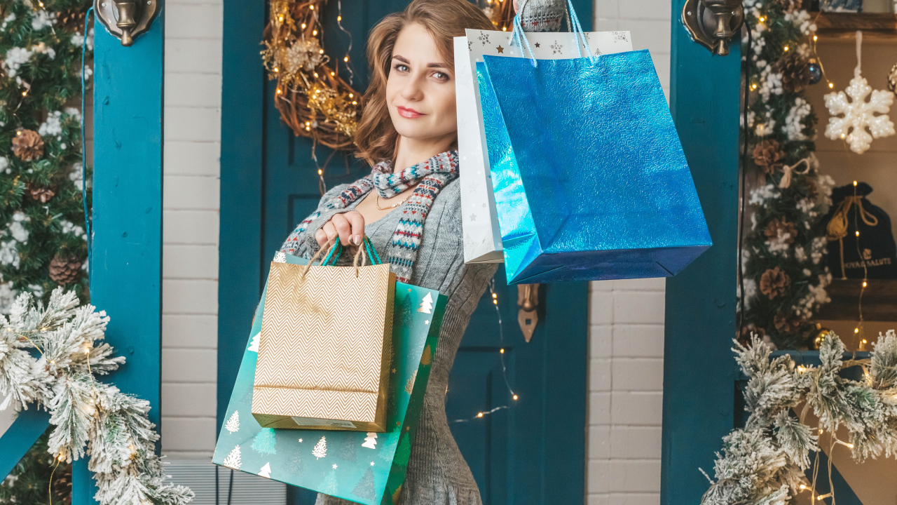 Девушка с пакетами стоит у двери