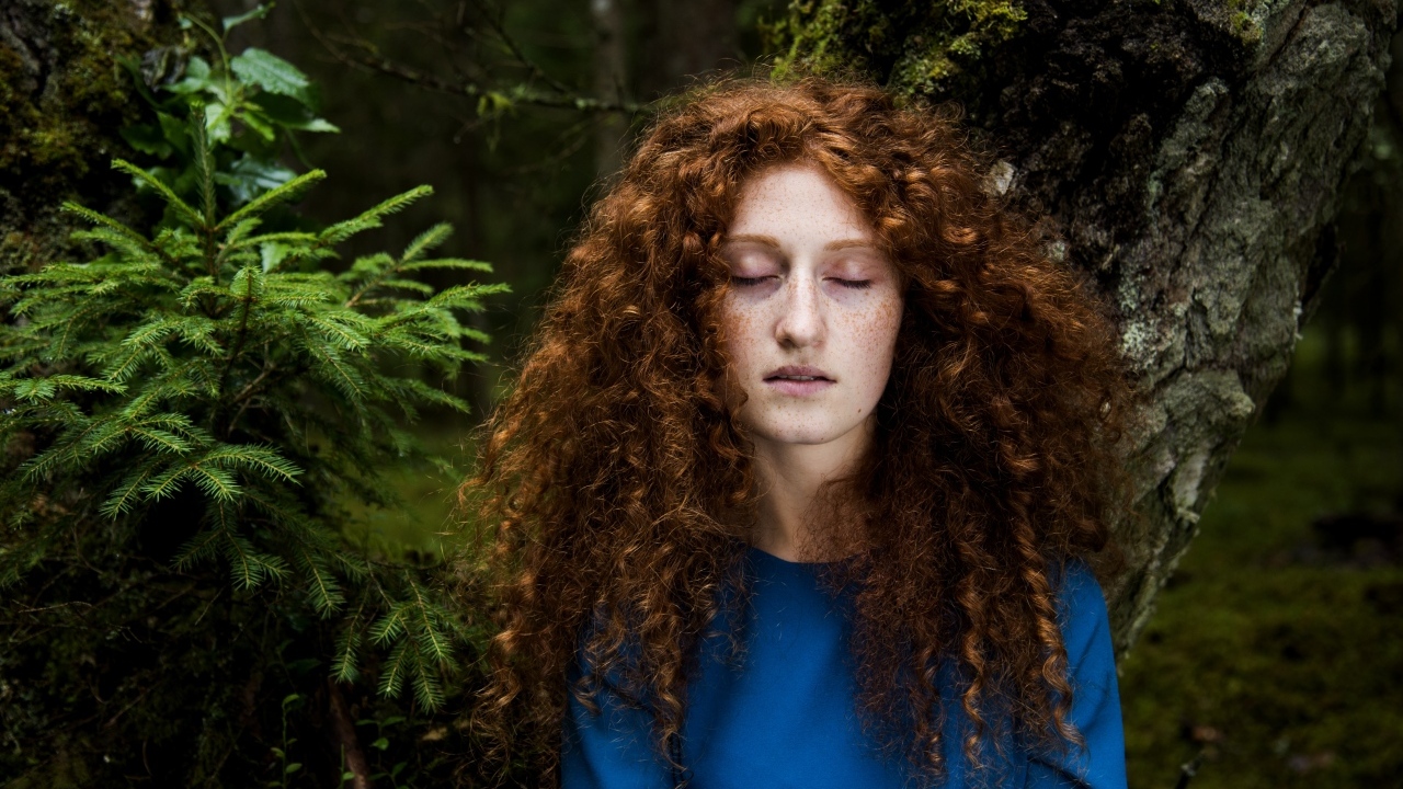 Девушка с кудрявыми волосами в лесу