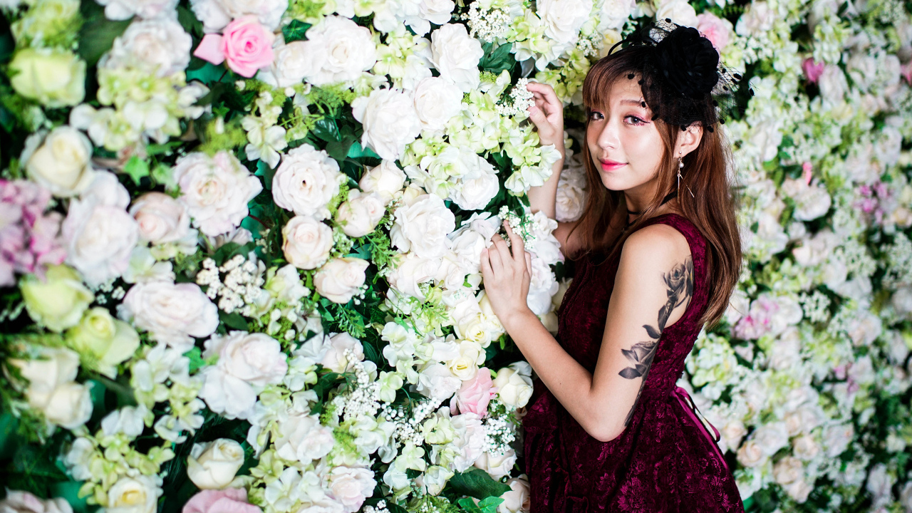 Молодая азиатка на фоне стены с розами