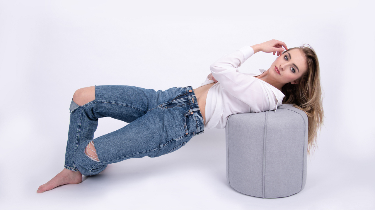 Молодая девушка в джинсах на белом фоне