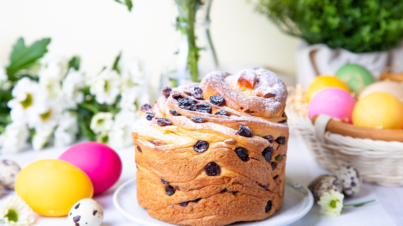 Красивый пасхальный кулич с сахарной пудрой и изюмом