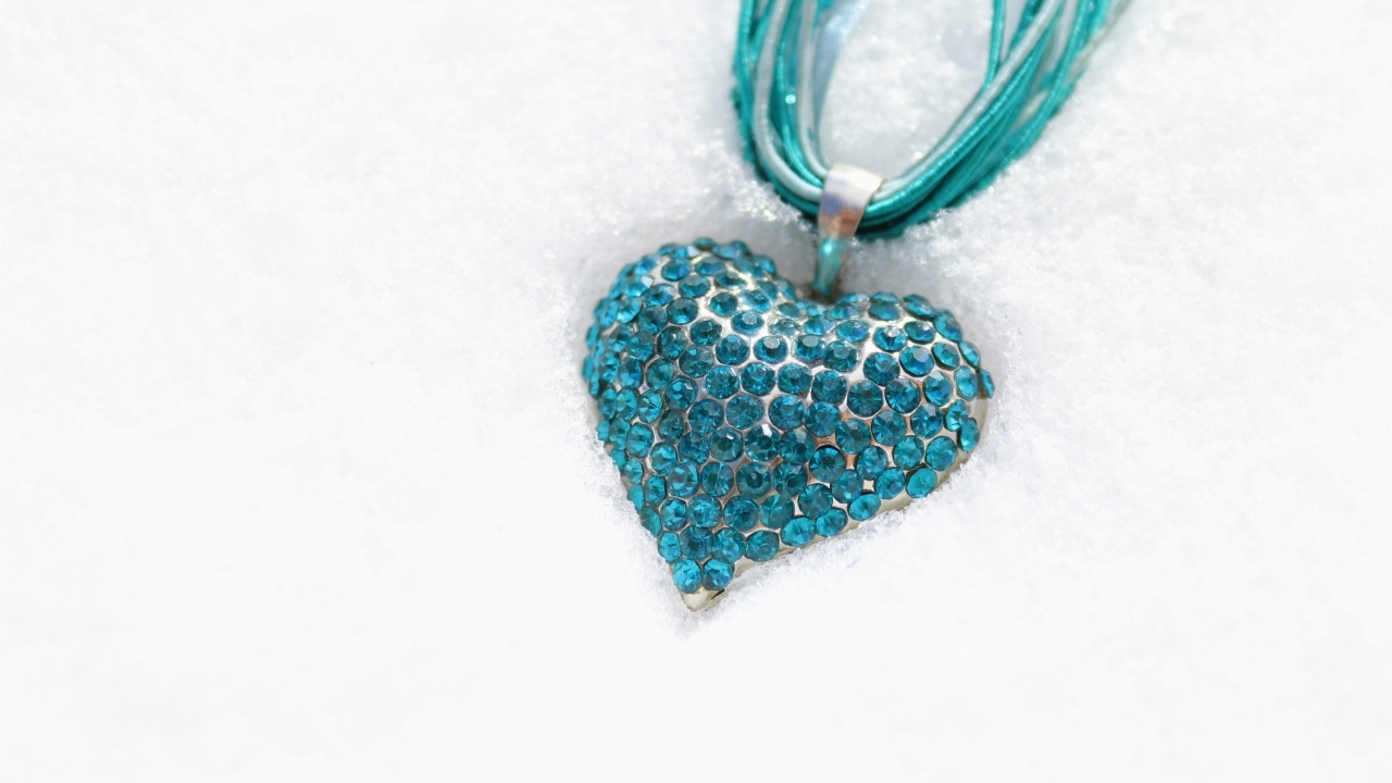 Голубой кулон в форме сердца на снегу