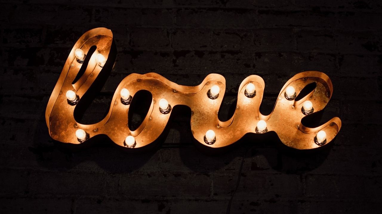 Светящаяся надпись любовь на черной стене