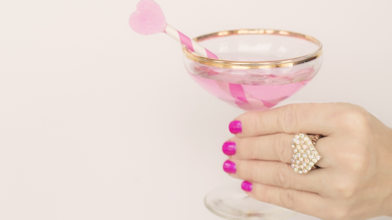 Кольцо в форме сердца на руке девушки с бокалом