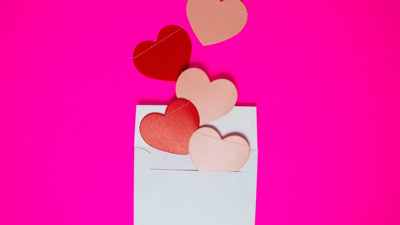 Сердечки с белым конвертом на розовом фоне