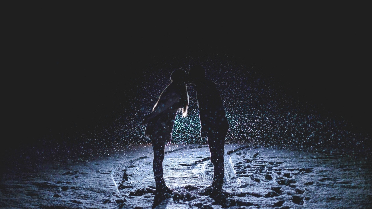 Поцелуй влюбленной пары на снегу ночью