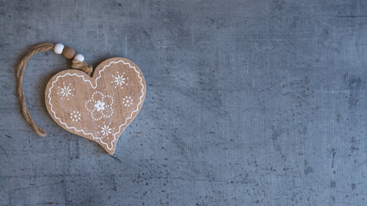 Деревянное сердце на нитке на сером фоне