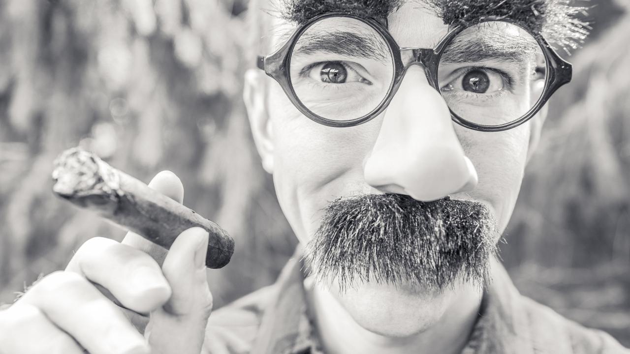 Мужчина в очках с сигарой в руке