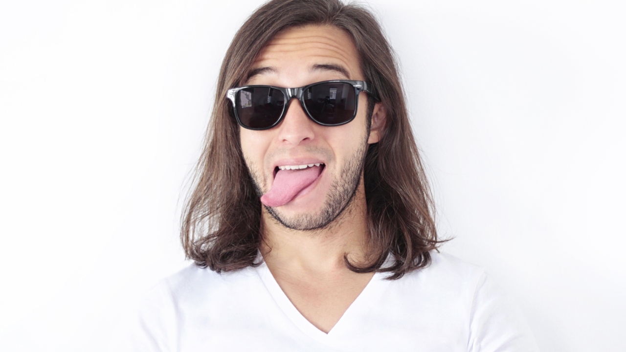 Мужчина в очках с высунутым языком