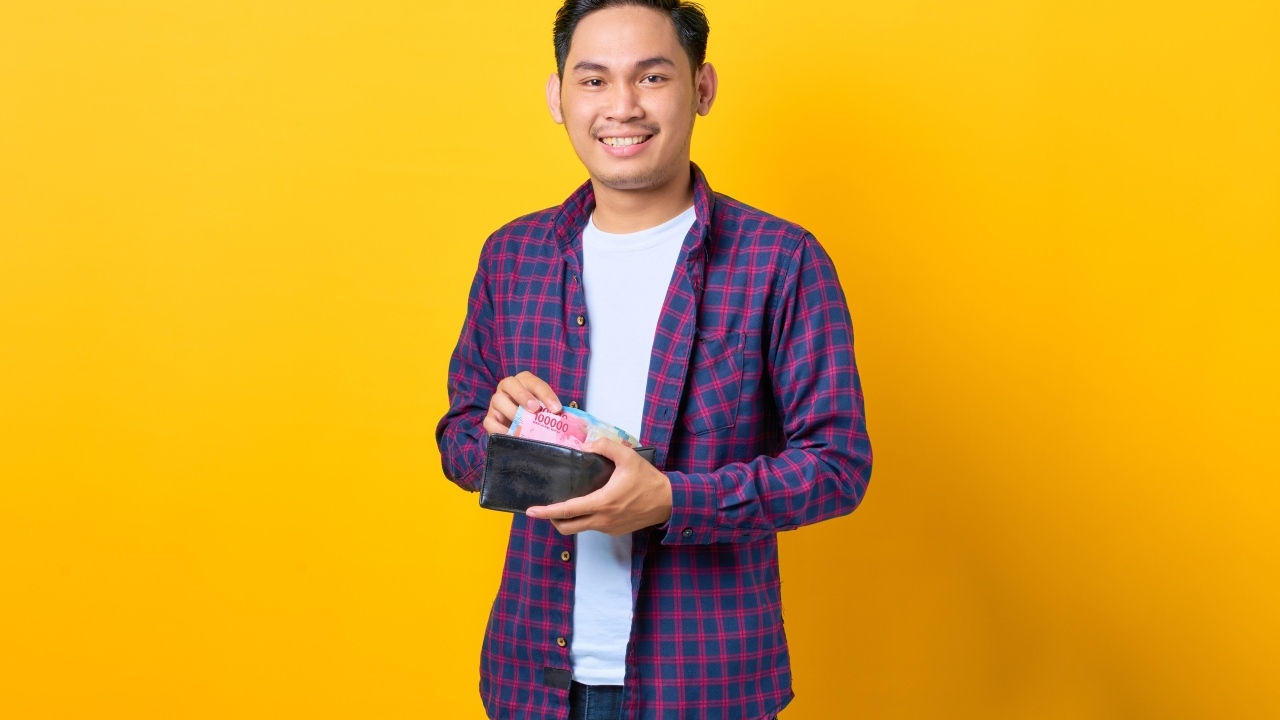 Улыбающийся мужчина с кошельком в руках