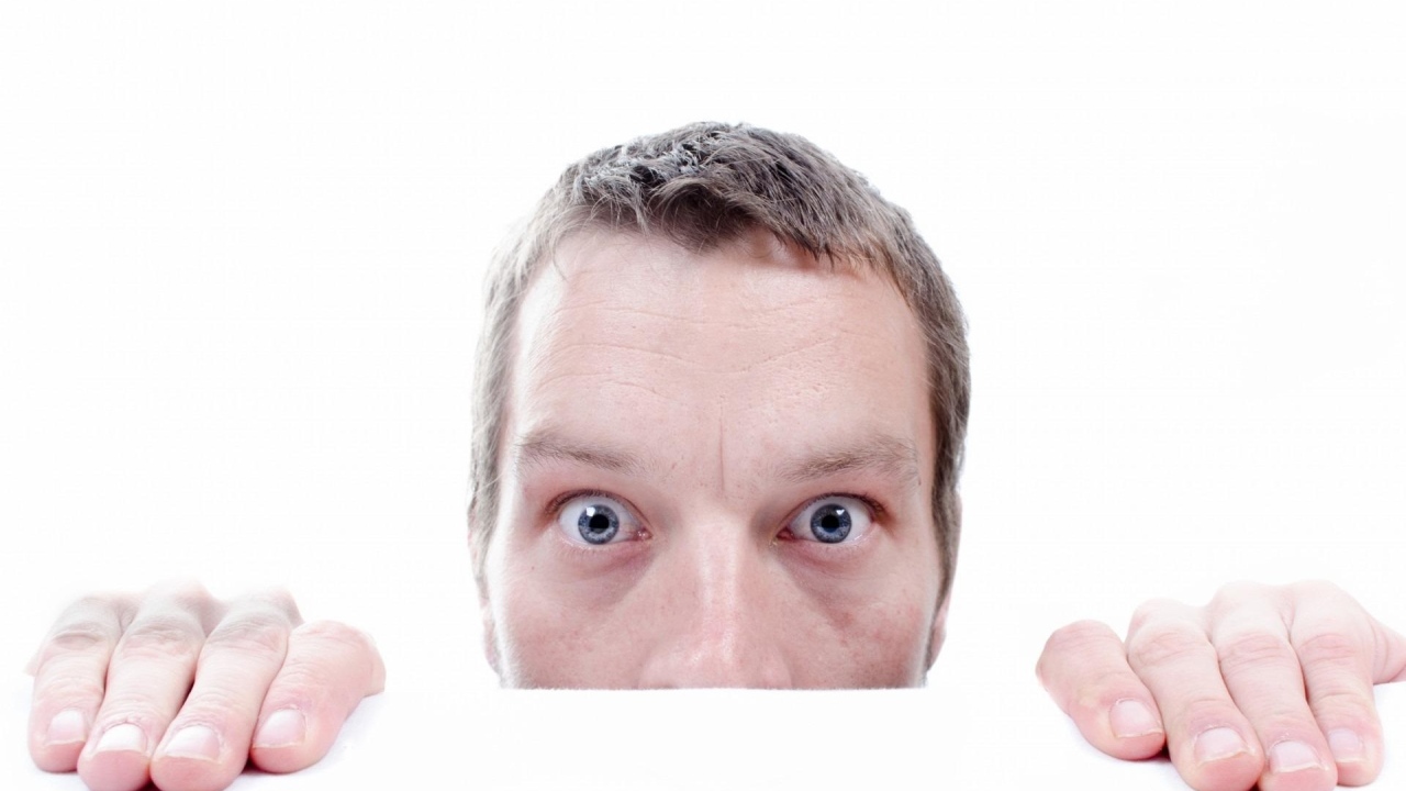 Удивленный взгляд мужчины на белом фоне