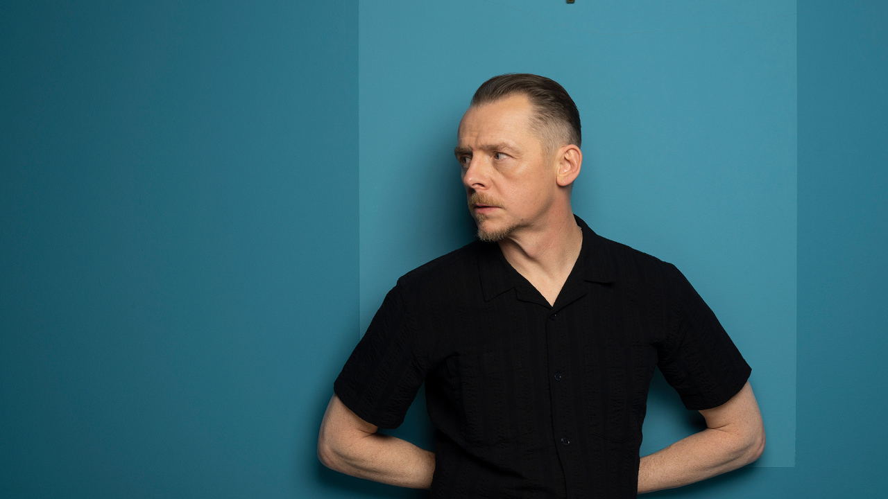 Актер Саймон Пегг  стоит у стены