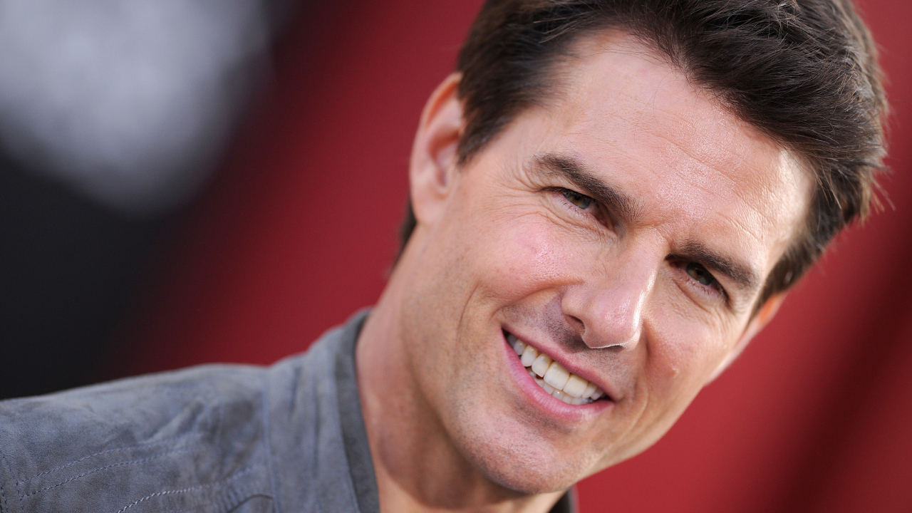 Актер Том Круз на красном фоне