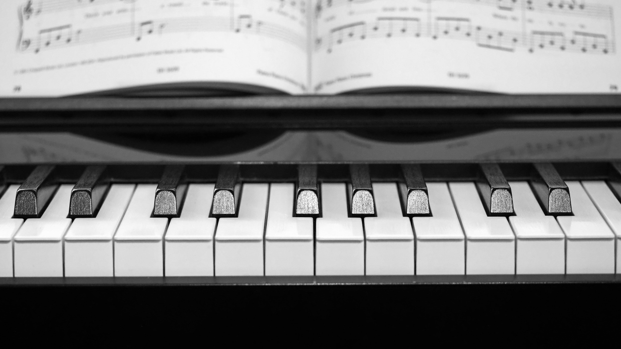 Клавиши пианино с нотной тетрадью