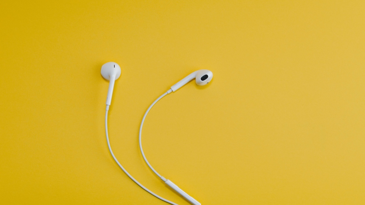 Белые наушники на желтом фоне