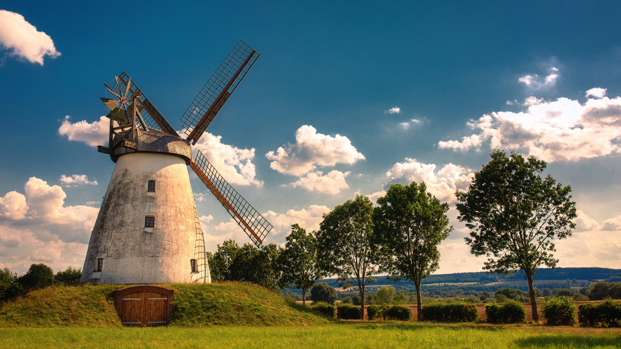 Старая мельница с зелеными деревьями