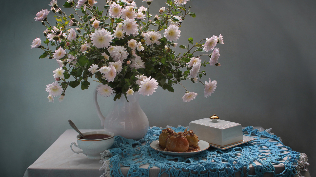 Букет белых хризантем стоит на столе с чаем