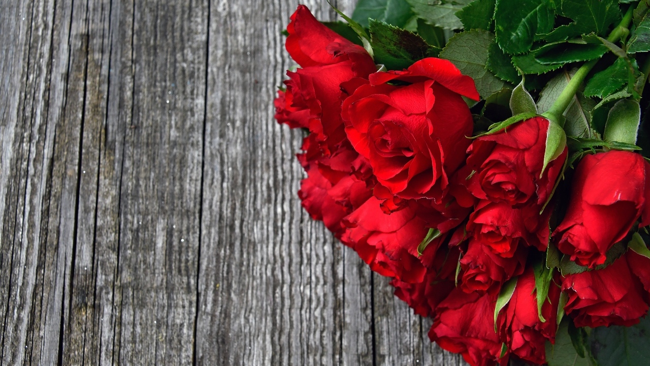 Букет красных роз на деревянном столе
