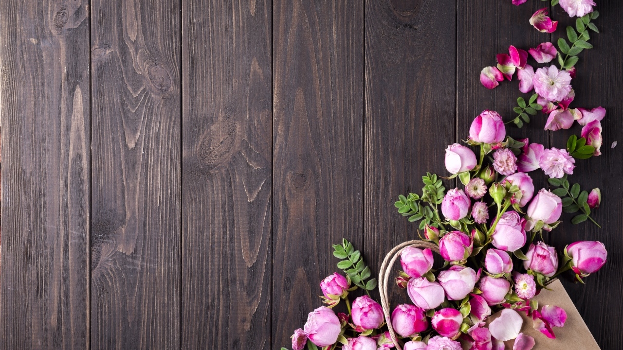Бутоны розовой розы на деревянном столе