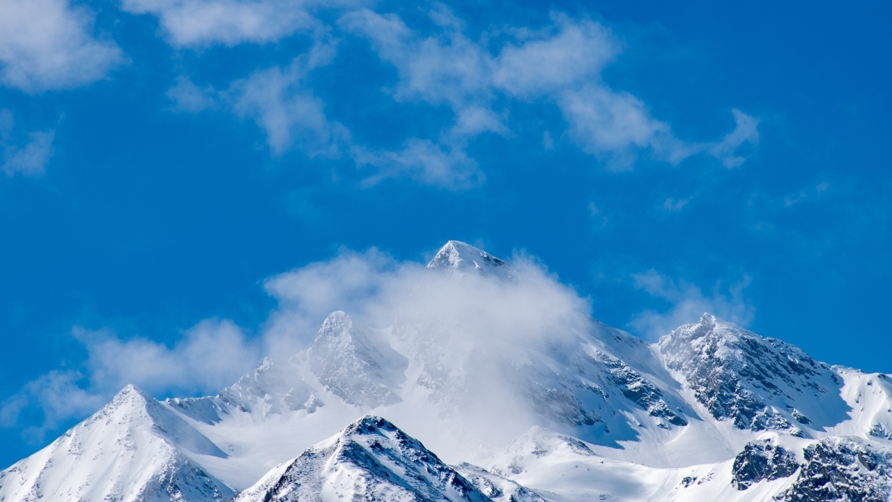 Голубое небо над покрытыми снегом горами