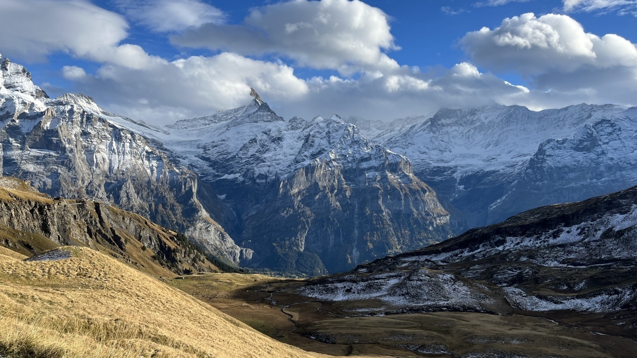 Высокие покрытые снегом горы в белых облаках