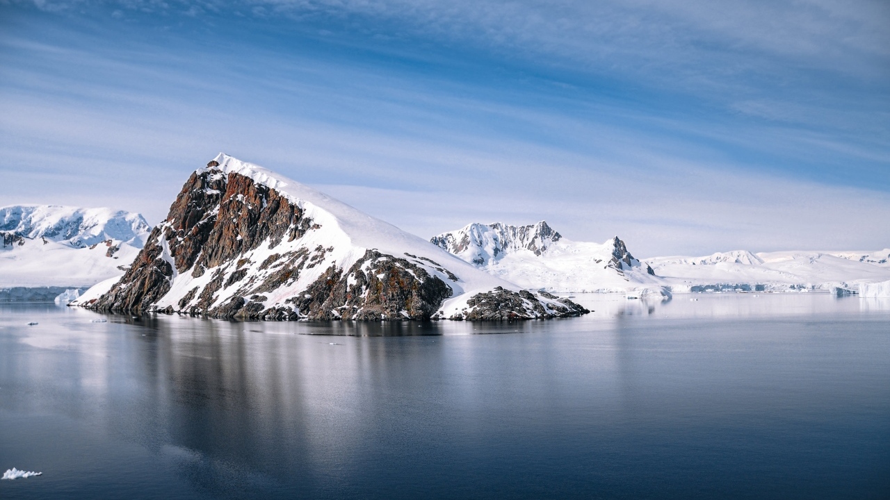 Скала в море покрыта снегом