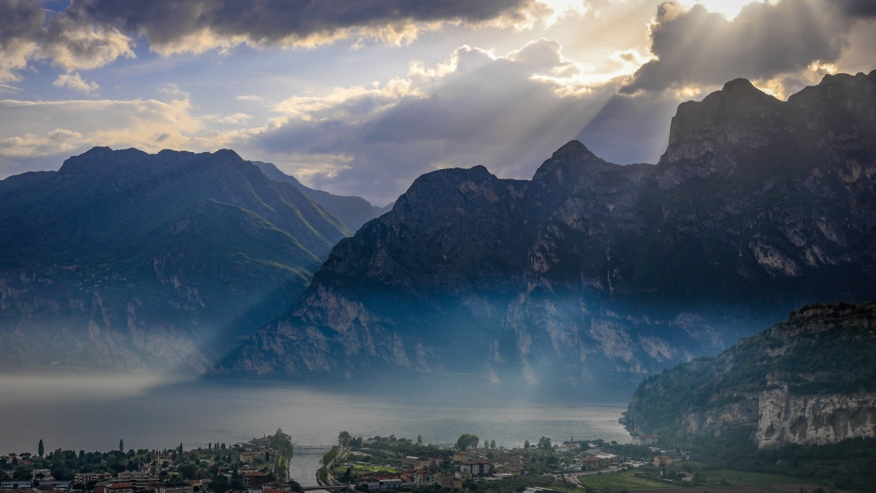 Лучи солнца покрывают горы и город 