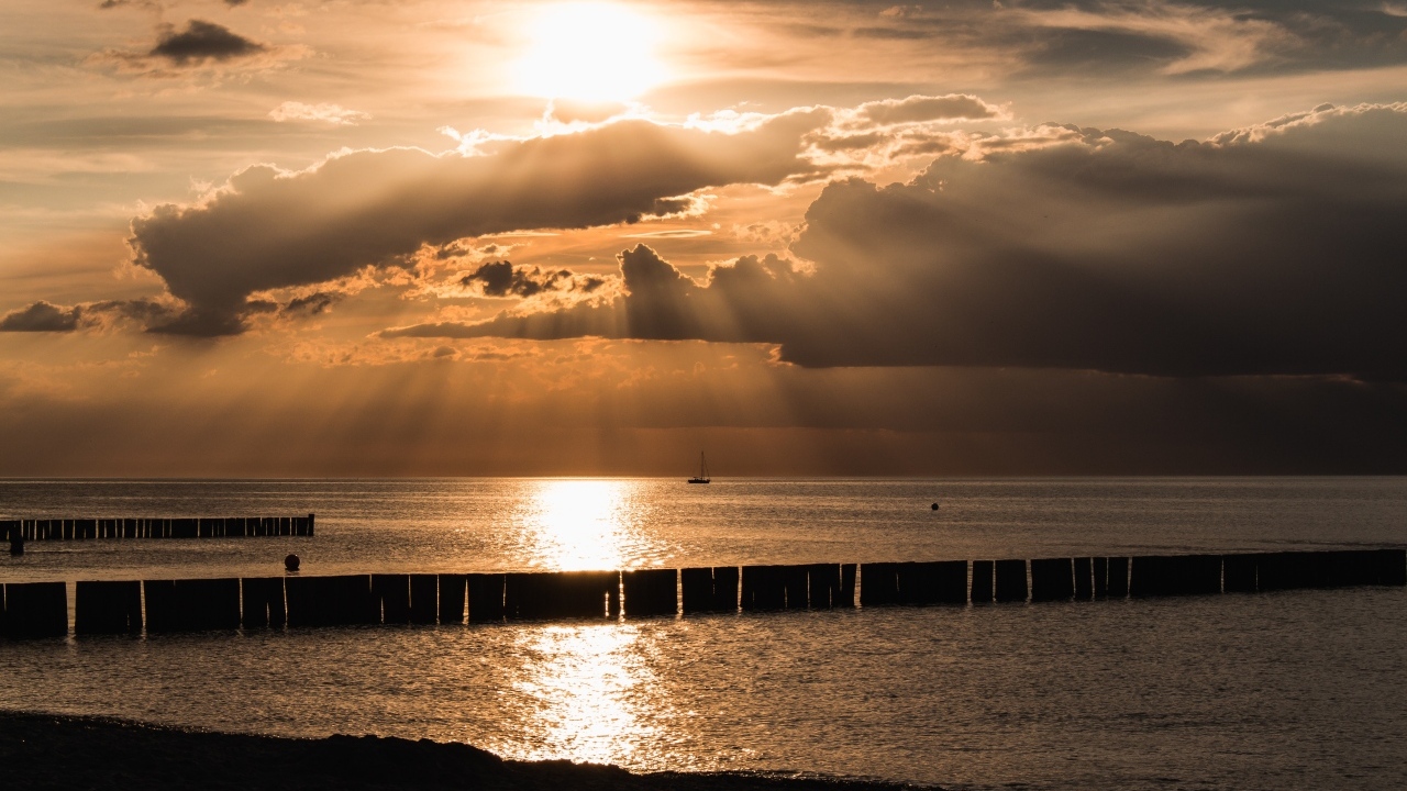 Яркое солнце за облаками над морем