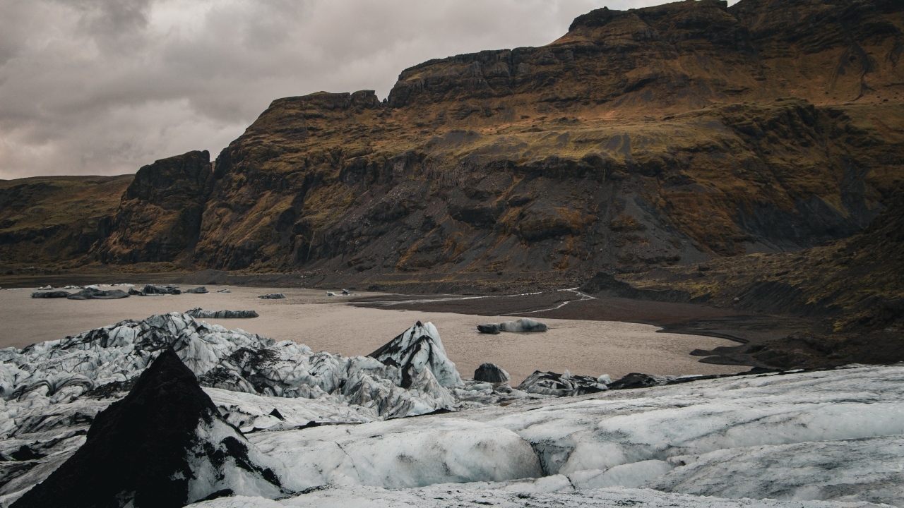 Холодный грязный снег на берегу моря у гор 