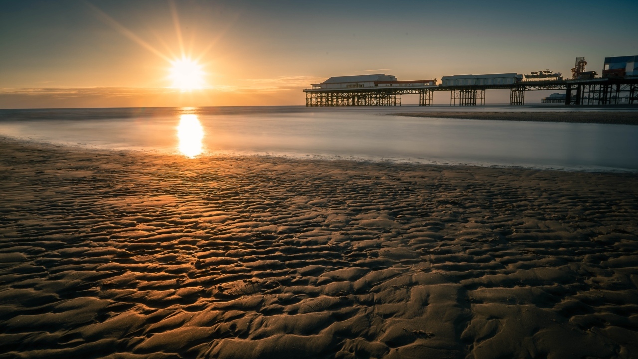 Мокрый песок на берегу моря на закате
