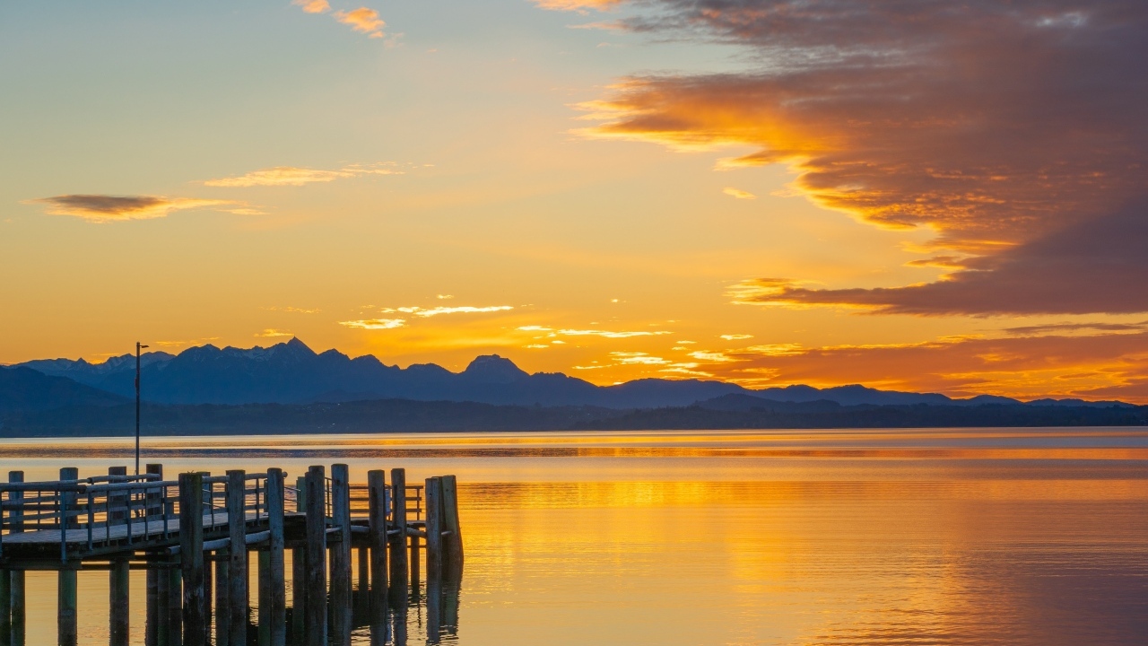 Красивый закат в небе над тихой водой озера