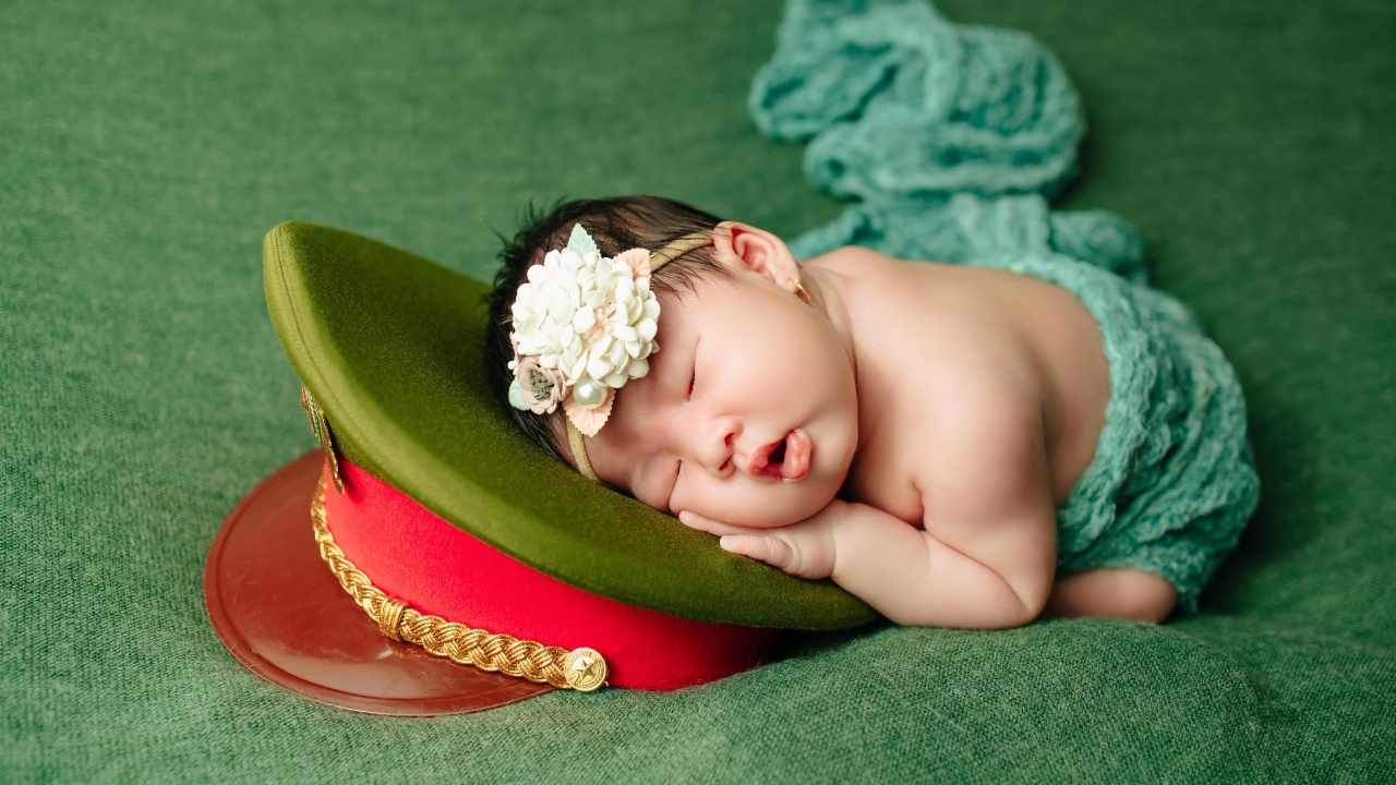 Маленький ребенок спит на военной фуражке