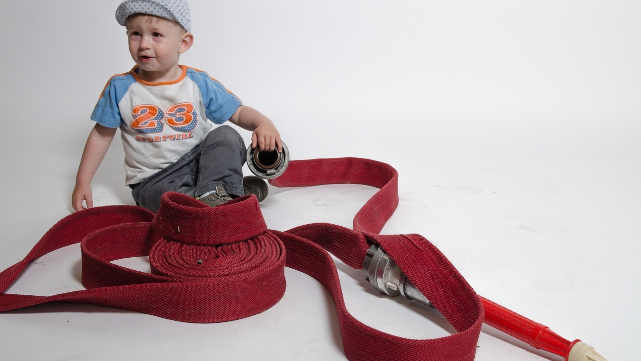 Мальчик с красным пожарным шлангом