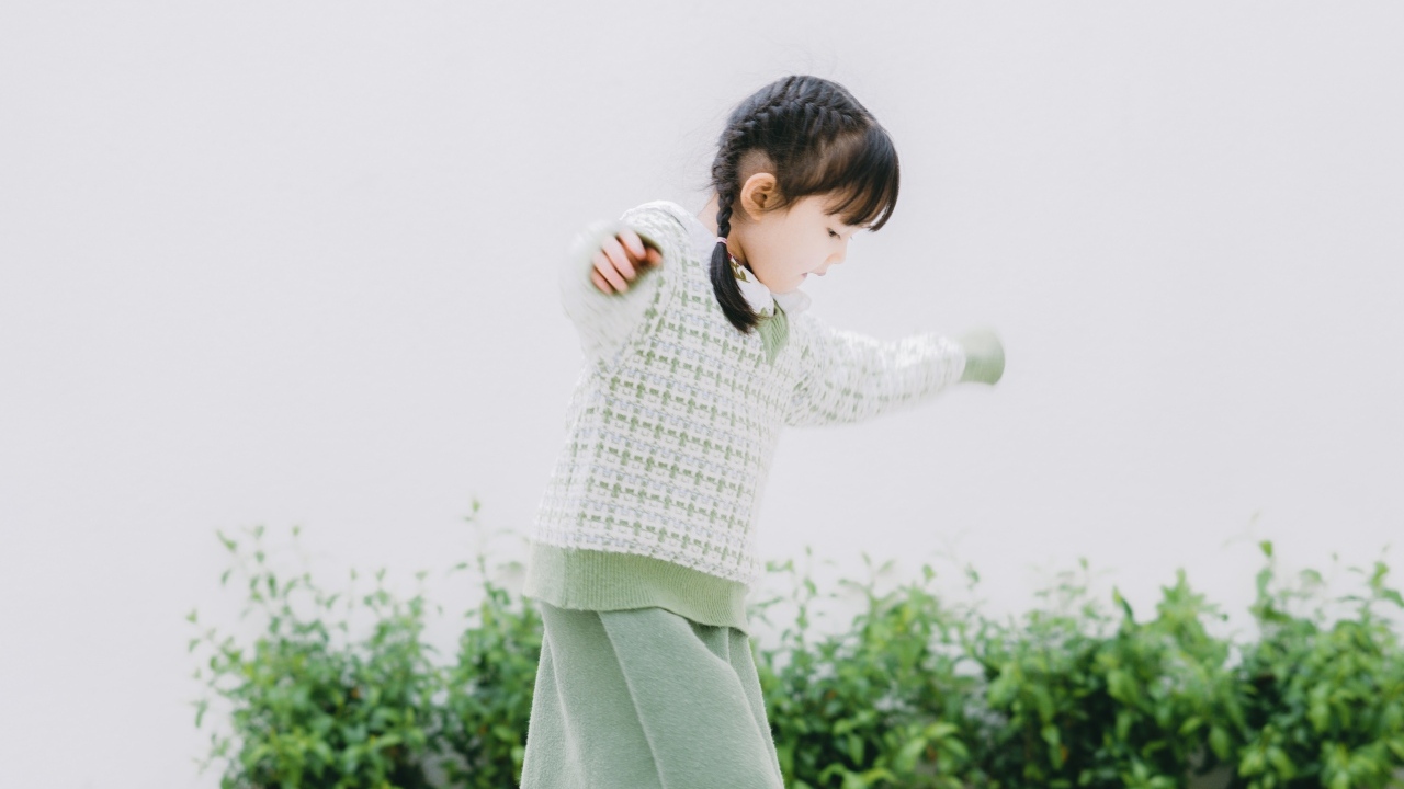 Маленькая девочка азиатка играет в саду