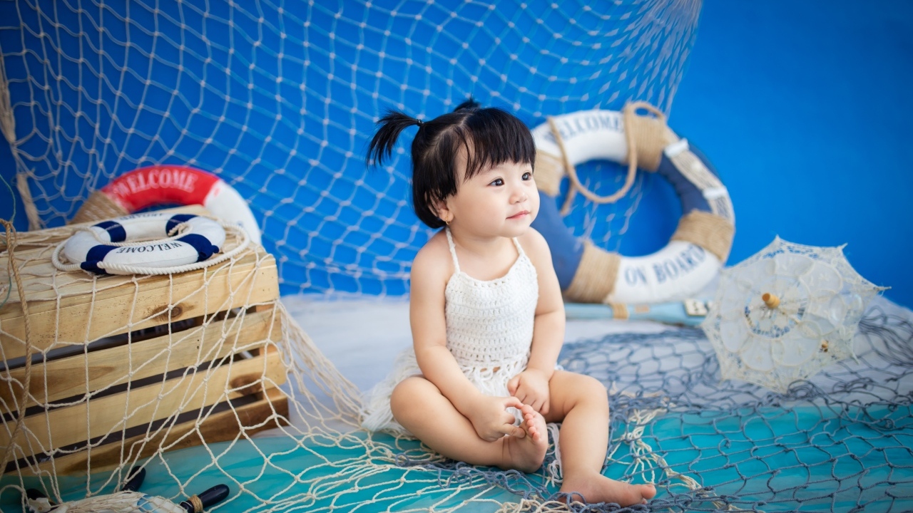 Маленькая девочка азиатка со  спасательным кругом и сетью 