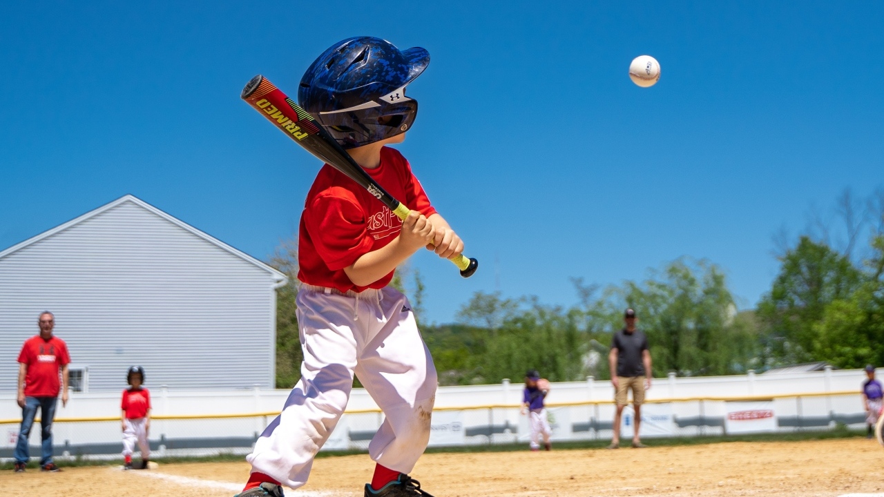 Маленький мальчик играет в бейсбол 