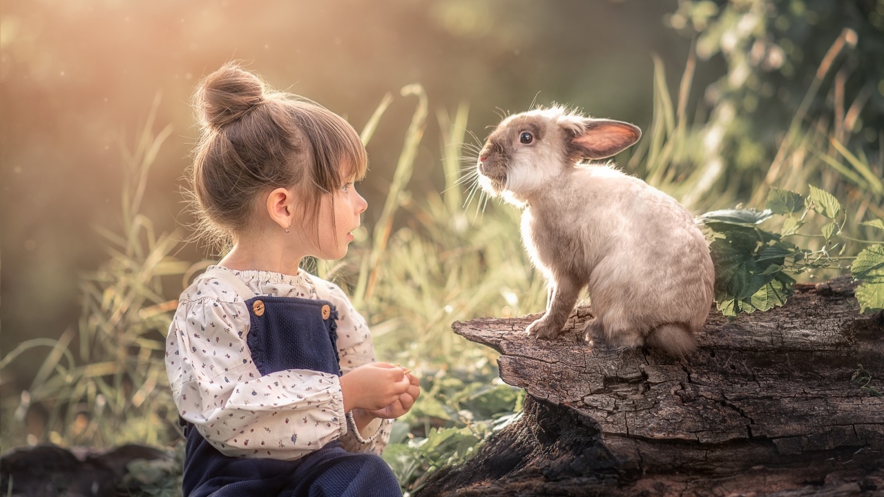 Маленькая девочка с кроликом в саду