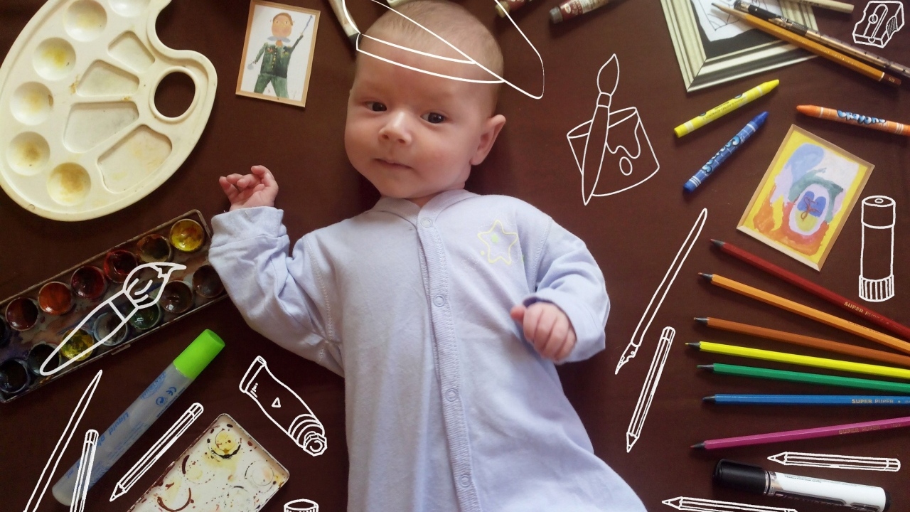 Новорожденный ребенок с канцелярскими предметами