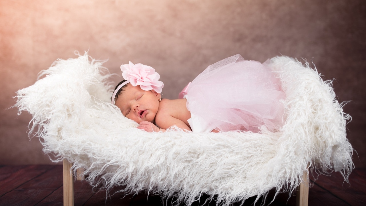 Спящая новорожденная девочка в пышной юбке