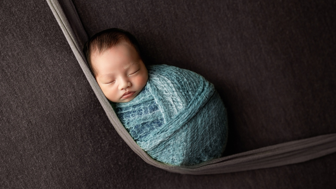 Маленький спящий ребенок завернут в покрывало