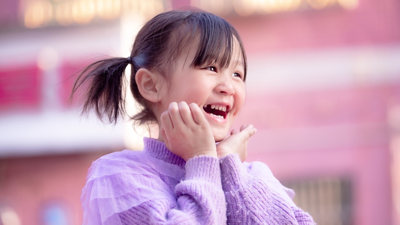 Улыбающаяся маленькая девочка азиатка в свитере