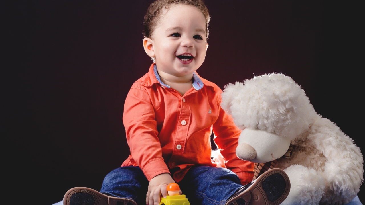 Улыбающийся мальчик с игрушечным медведем