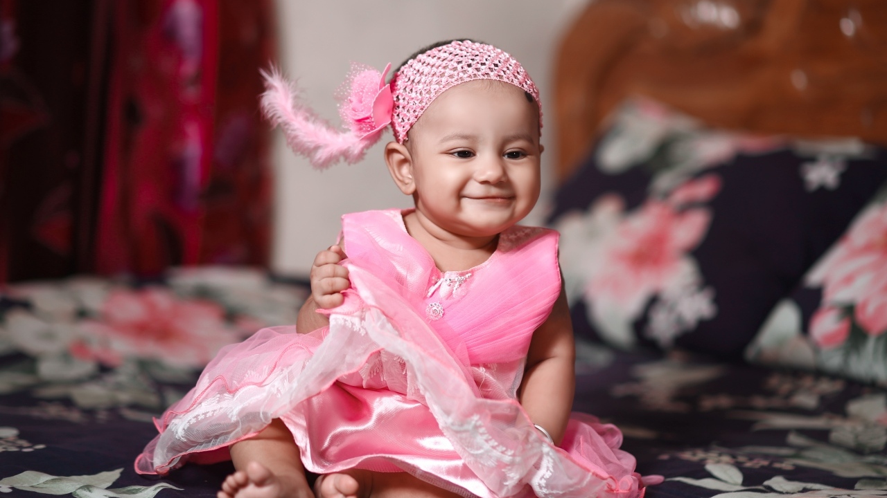 Улыбающаяся девочка в красивом розовом платье